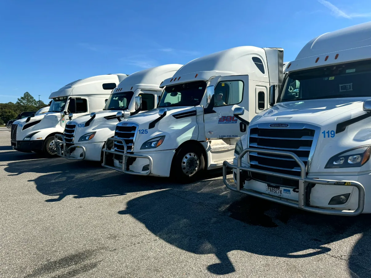 Snowbirds Auto Connection company-owned fleet of white Freightliner Cascadia trucks lined up at the terminal